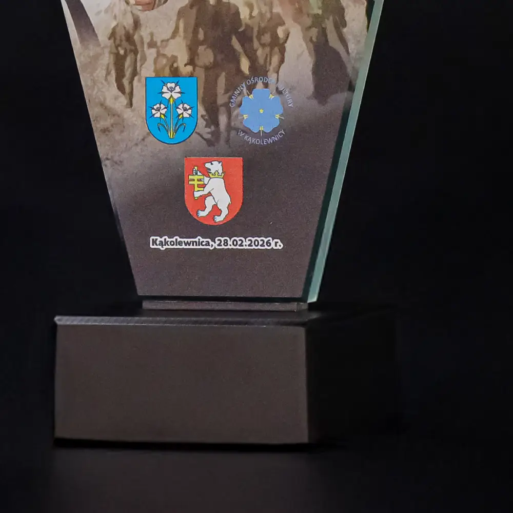 Detale podstawy statuetki z widocznymi herbami miast i logotypem organizatora turnieju karate.