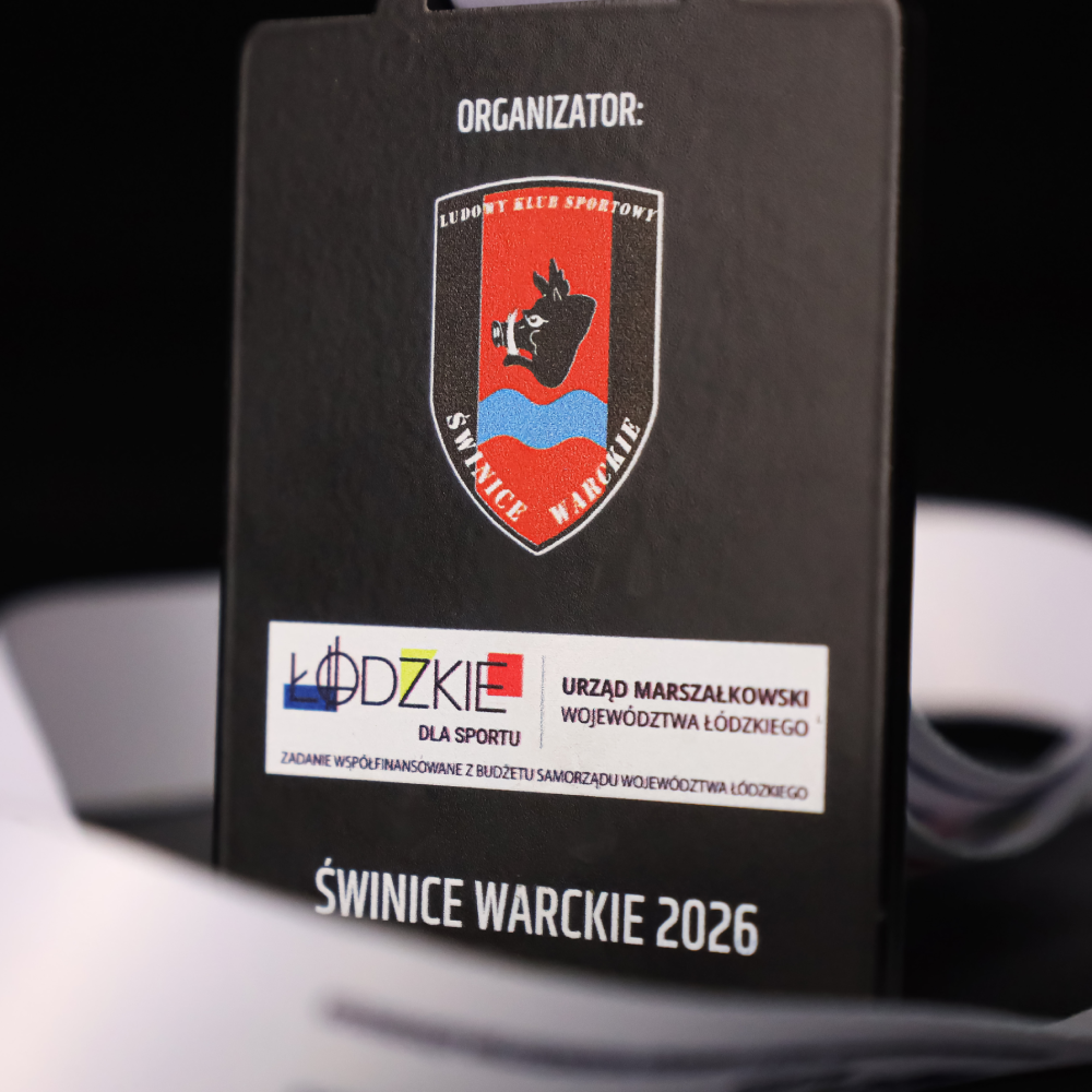 Widok na gładki, czarny rewers medalu z kolorowym herbem klubu LKS Świnice Warckie, napisem z datą 2026 oraz logotypami województwa łódzkiego.